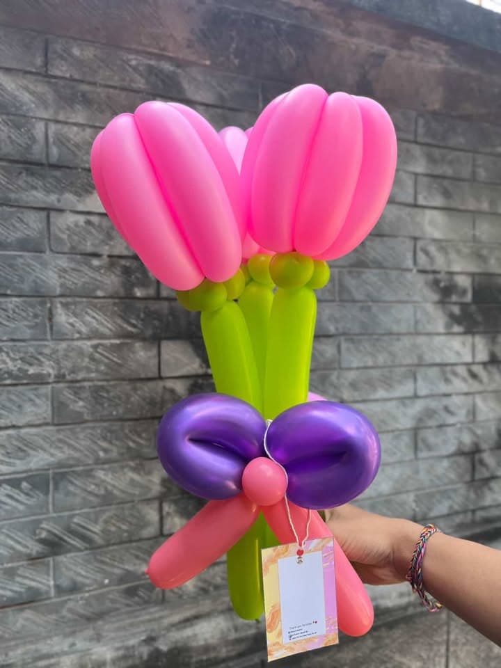 Buket tiga tangkai tulip balon merah muda elegan diikat pita ungu satin untuk kado wisuda
